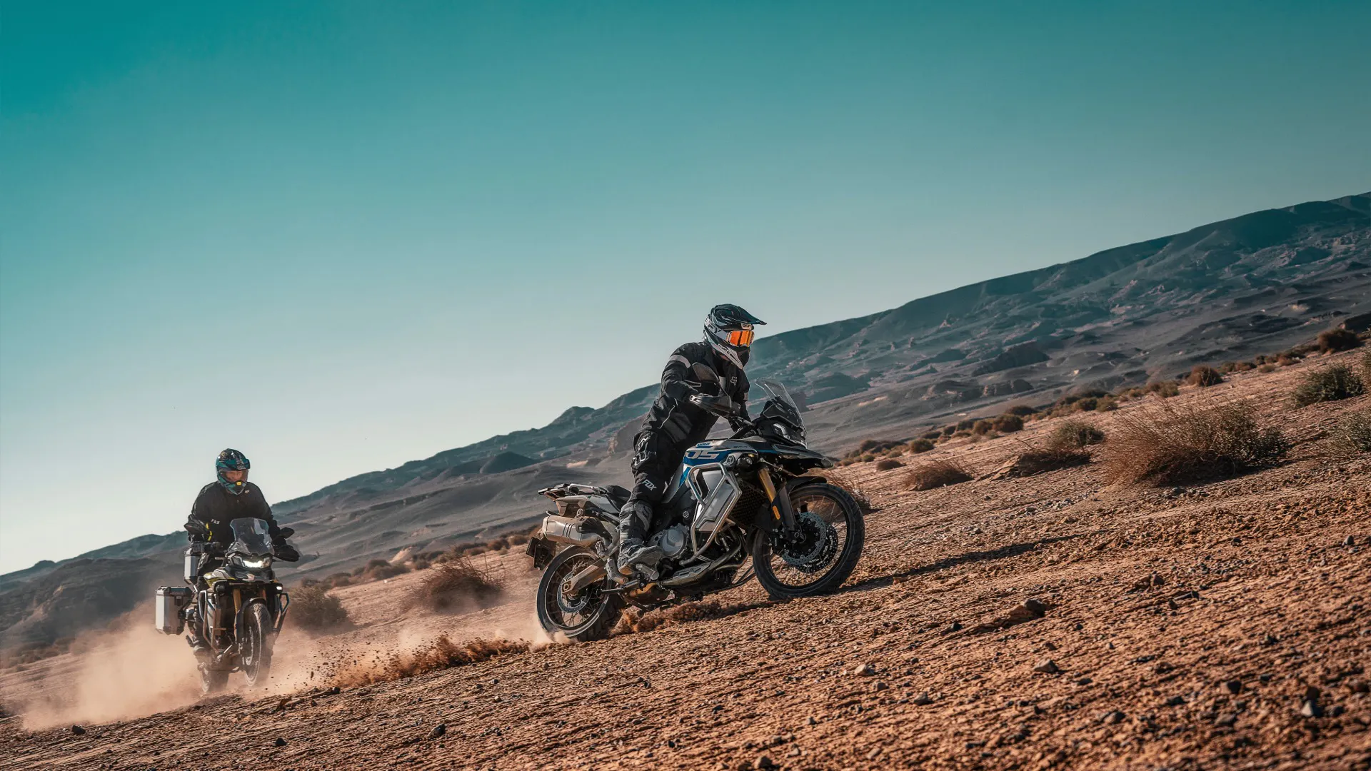 VOGE adventure motorcycles riding through desert landscape